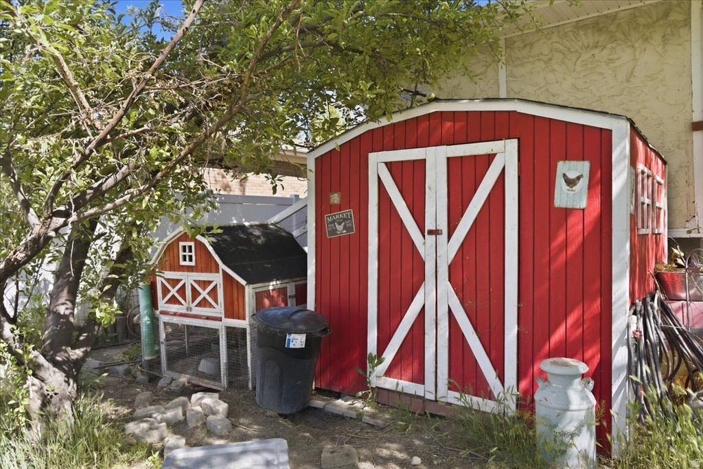 Red barn-style shed featuring white trim and double doors