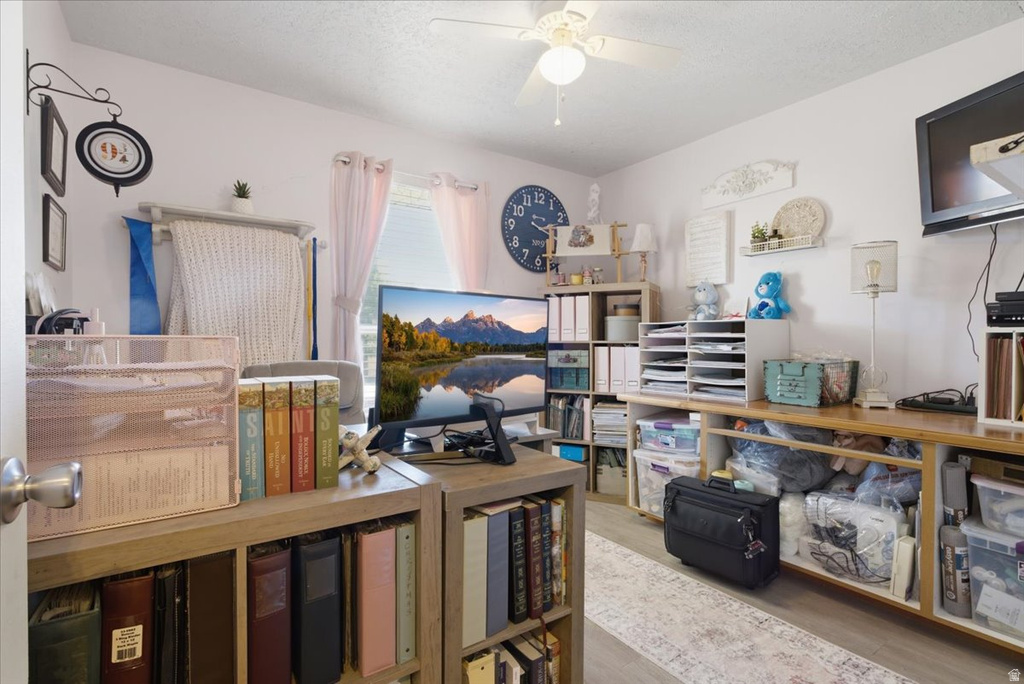 Dedicated room featuring a ceiling fan, window with curtains, and wood-finish flooring