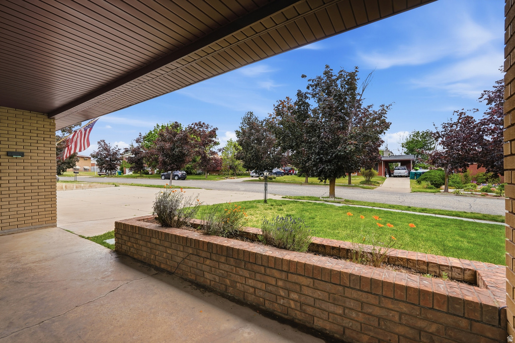 Covered entryway featuring a brick facade and a built-in planter box