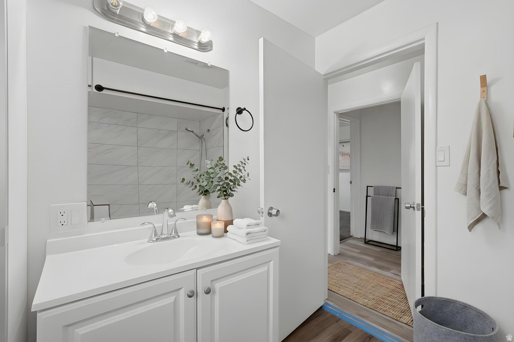 Bathroom vanity featuring an integrated sink, polished chrome faucet, and a large mirror
