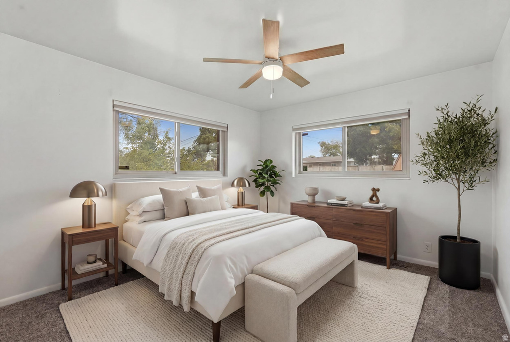 Bedroom featuring two horizontal windows, a ceiling fan with light fixture, light gray carpet, and white painted walls