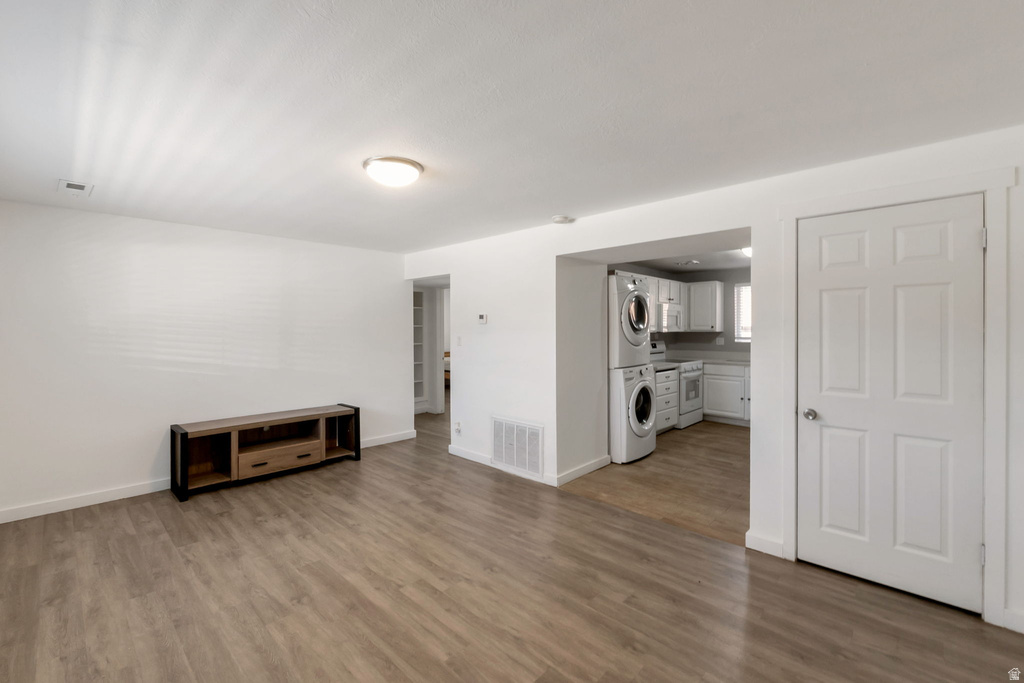 Open-concept living space featuring wood-finish flooring, white baseboards, and a neutral color palette