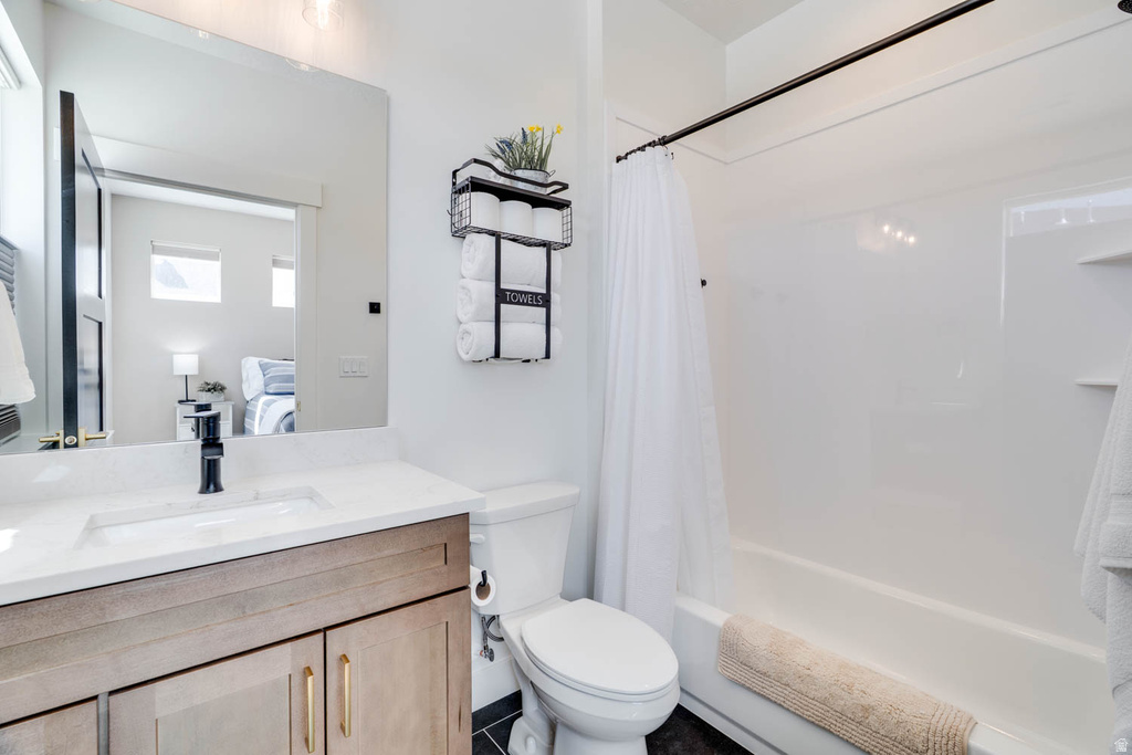 Bathroom featuring a wood-finish vanity with gold-tone hardware, rectangular undermount sink, and a white countertop