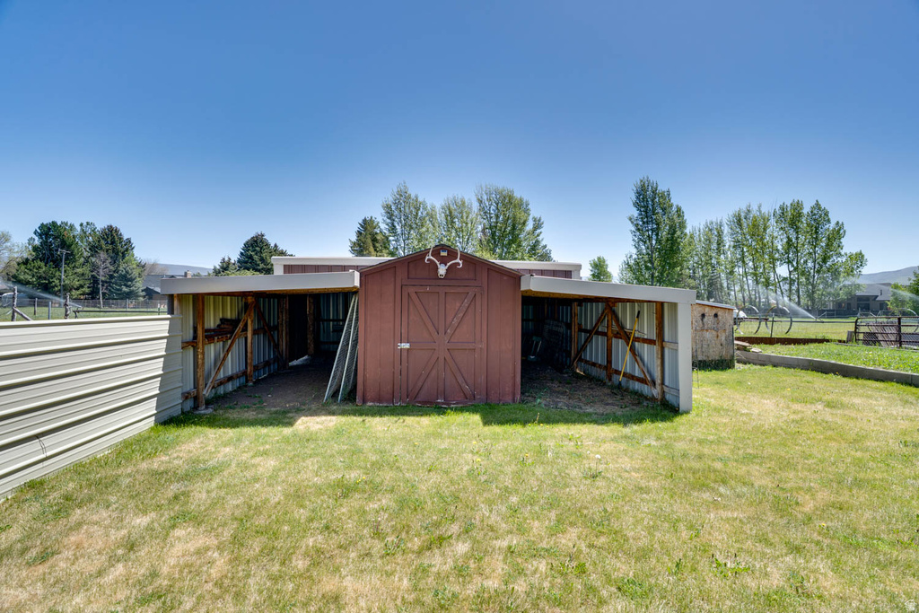 Utility shed with red siding and white trim, featuring double doors