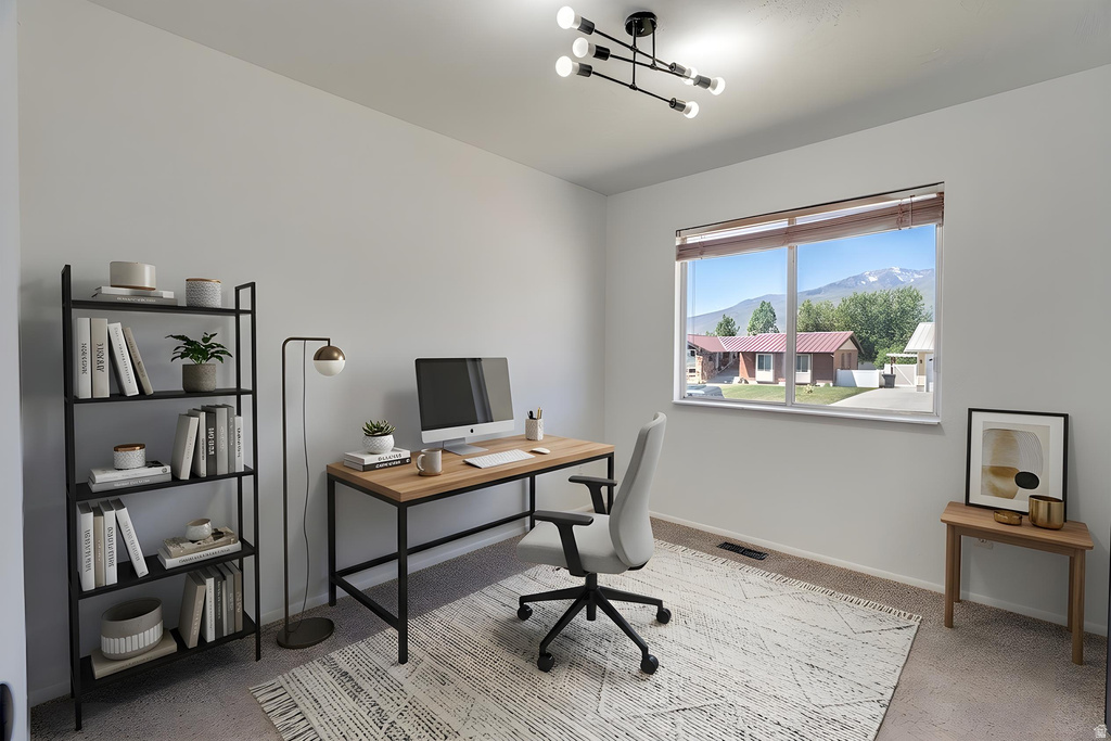 Bright room featuring a large window with mountain scenery, a contemporary ceiling light fixture, and neutral wall tones