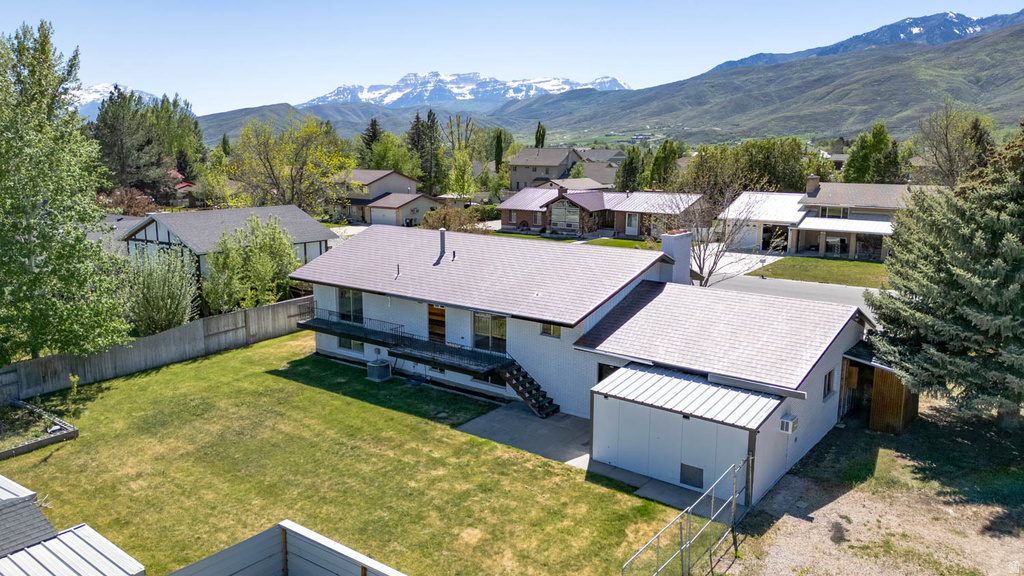 Expansive rear yard featuring a manicured lawn, established landscaping, and a fenced perimeter