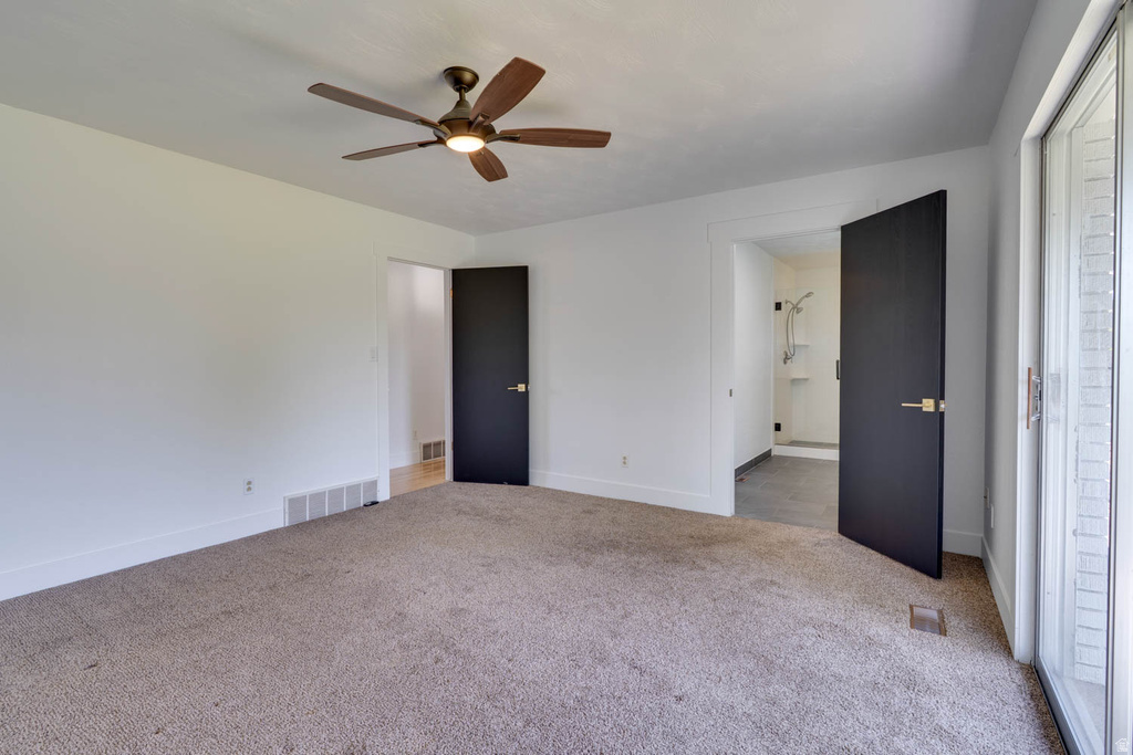 Carpeted room featuring a ceiling fan with integrated lighting, white walls, and bright white trim