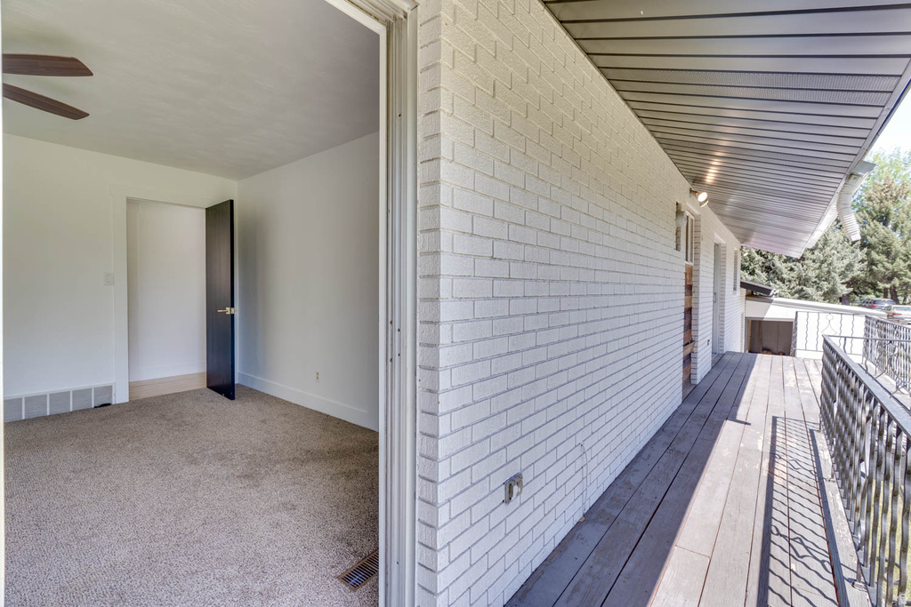 Outdoor decking with a black metal railing and white painted brick exterior