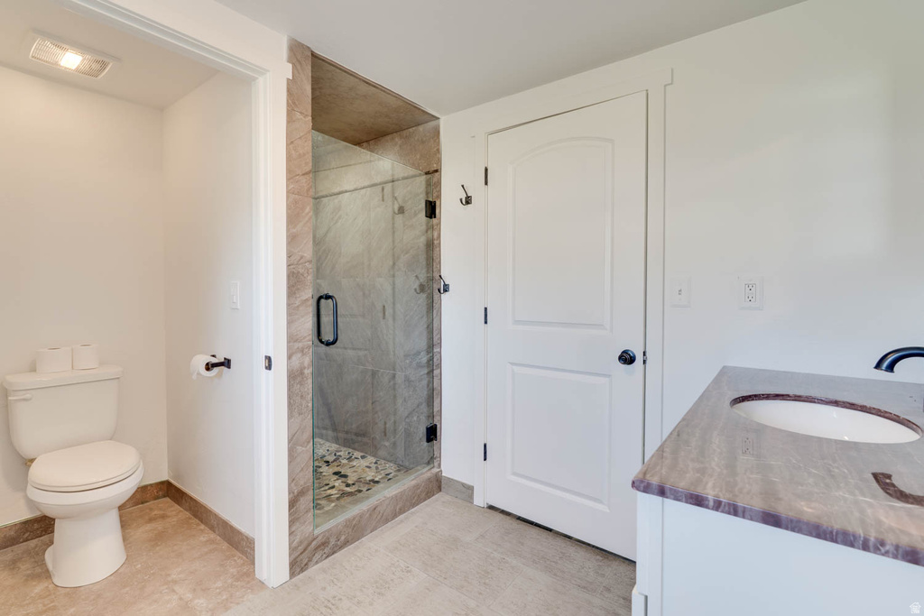 Walk-in shower with clear glass enclosure and stone-look tile surround