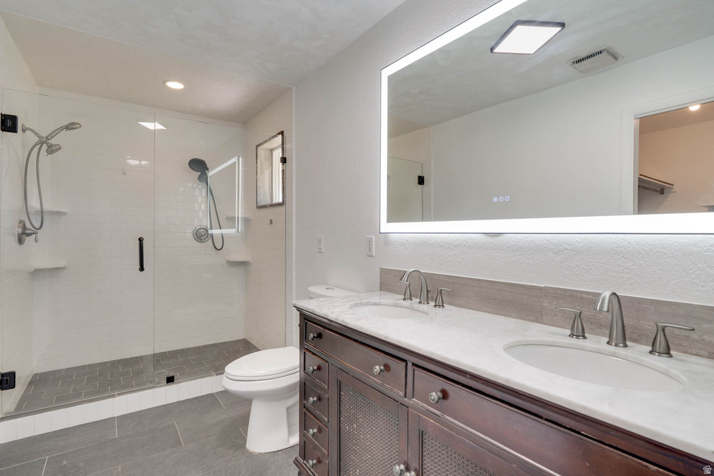 Dual vanity with integrated sinks, brushed nickel fixtures, and a large illuminated mirror