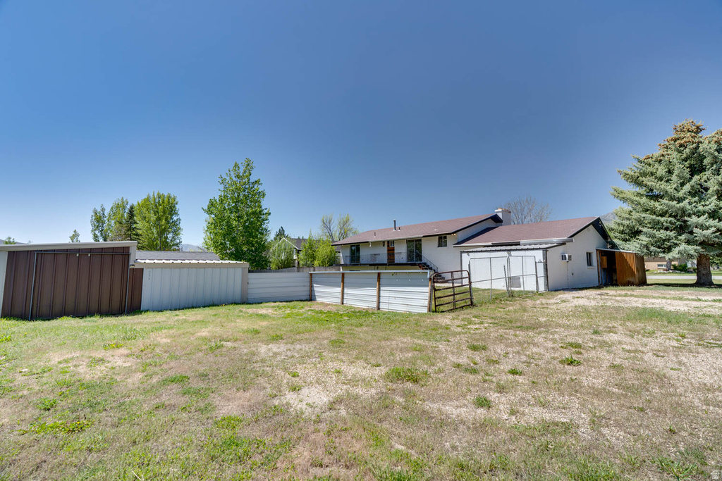 Expansive exterior featuring a brown metal utility structure and multiple white-sided outbuildings