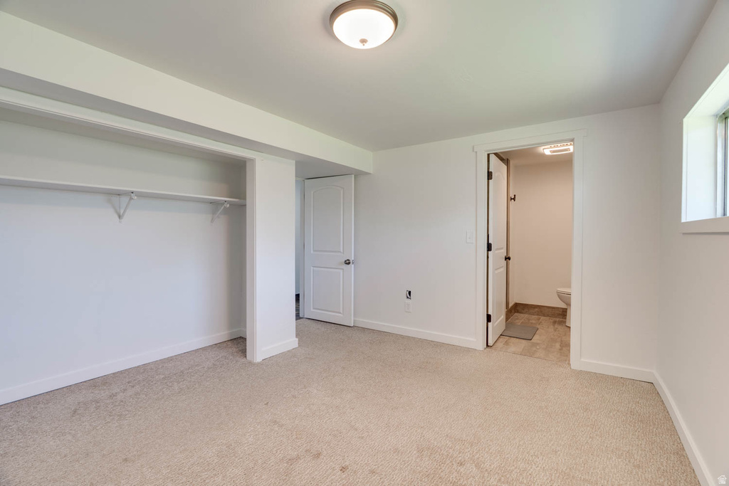 Room with neutral carpet, white walls, and a visible window