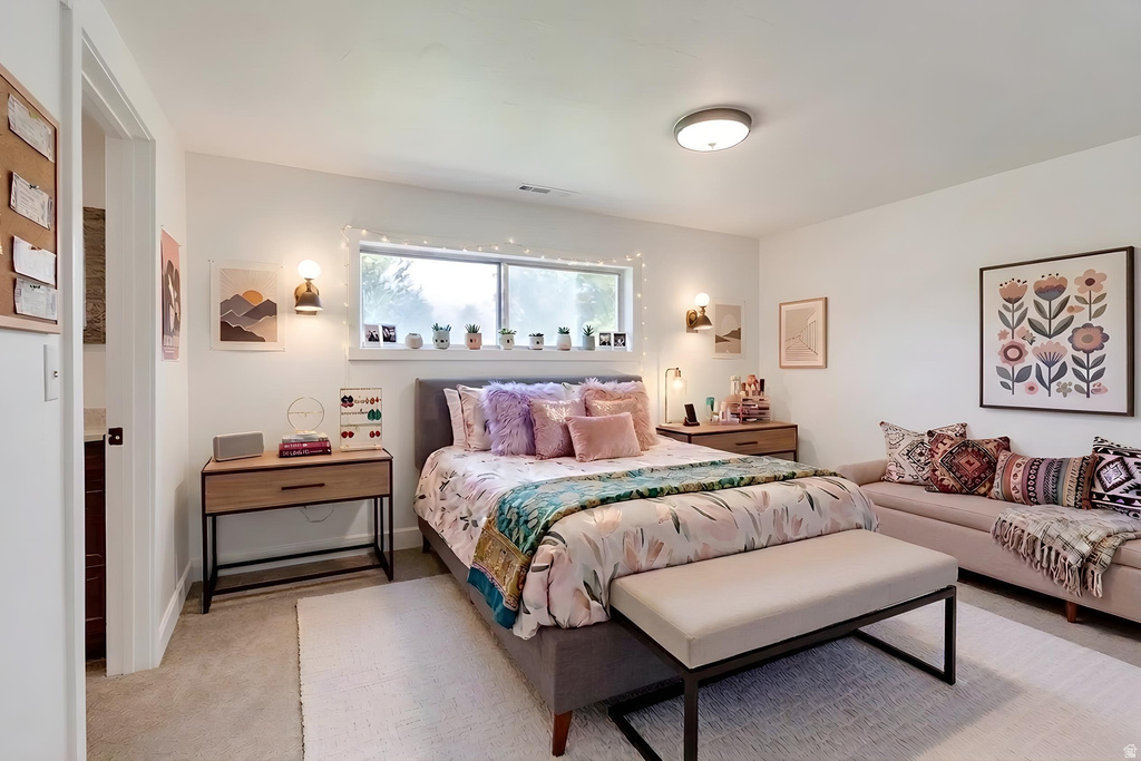 Spacious room featuring white walls, light gray carpet, and a large window providing ample natural light