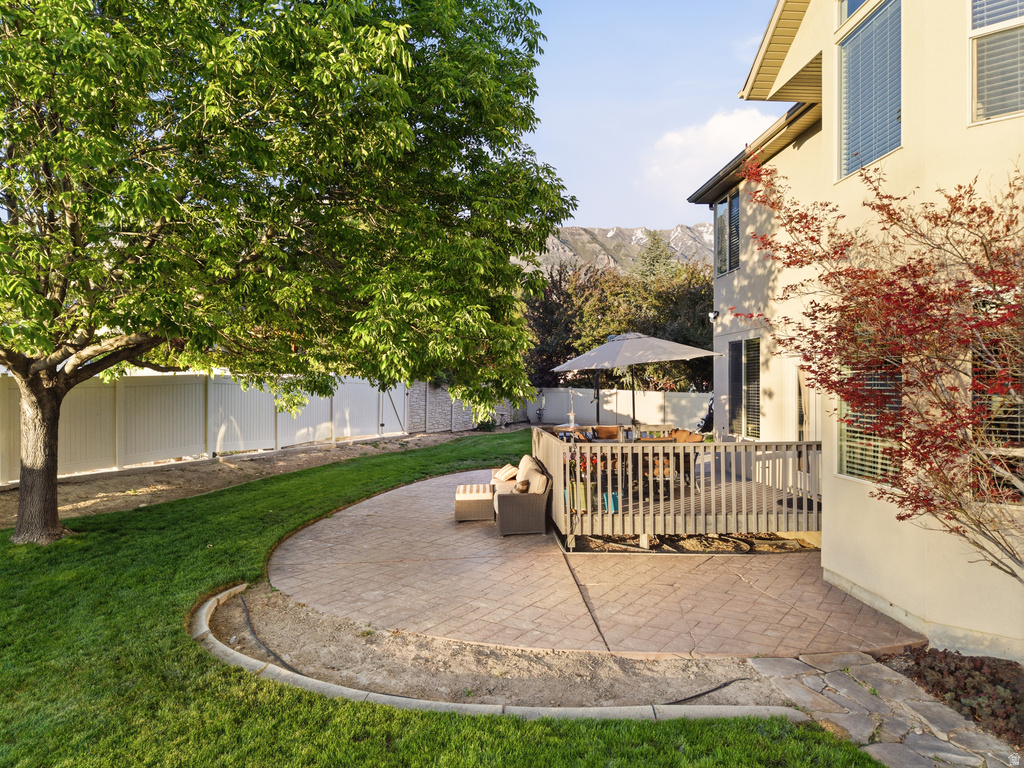 Expansive exterior featuring a wood deck, stamped concrete patio, and a manicured lawn
