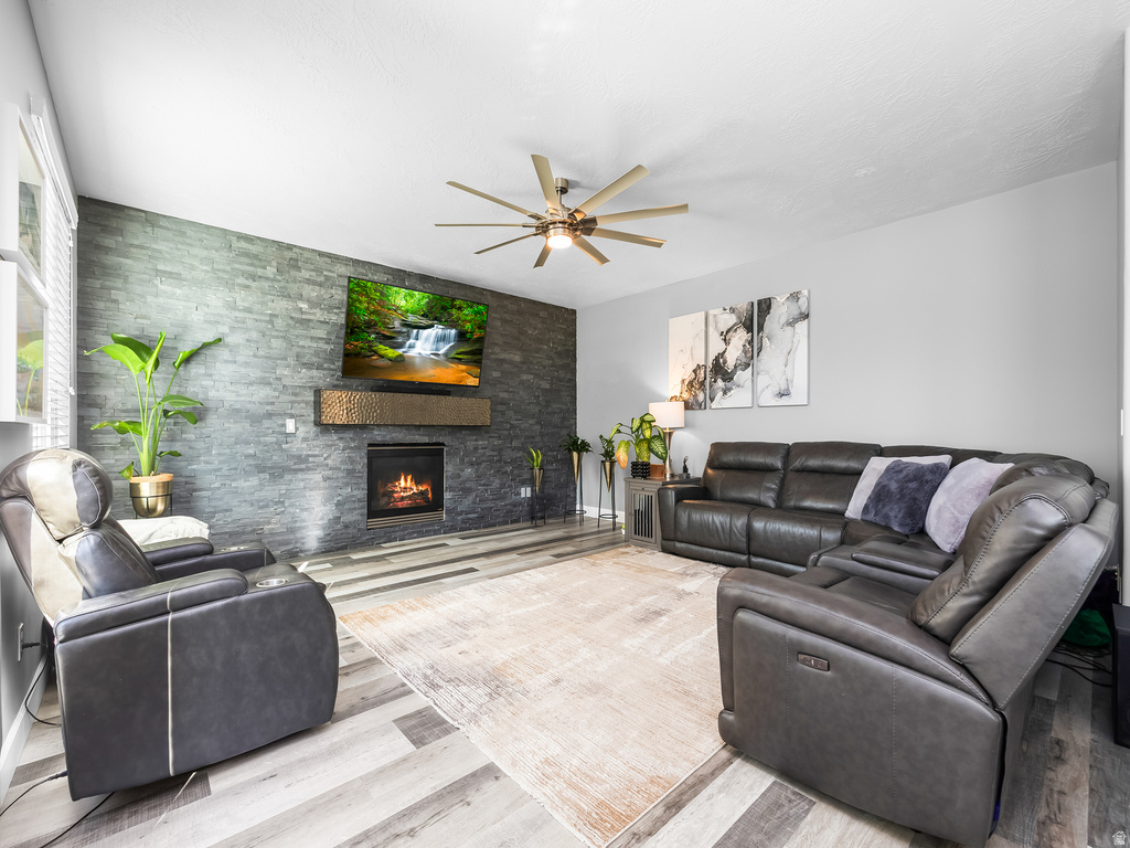 Living area featuring a floor-to-ceiling stacked stone accent wall with a built-in fireplace
