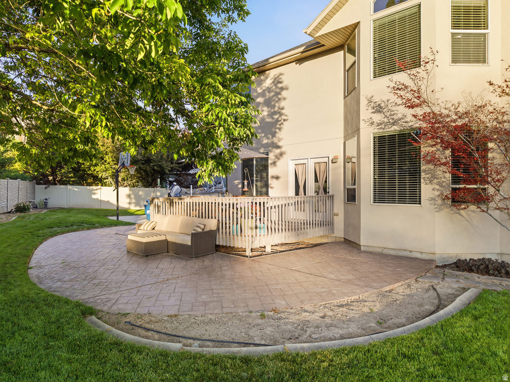 Expansive backyard featuring a large stamped concrete patio, a multi-level wooden deck, and a manicured lawn