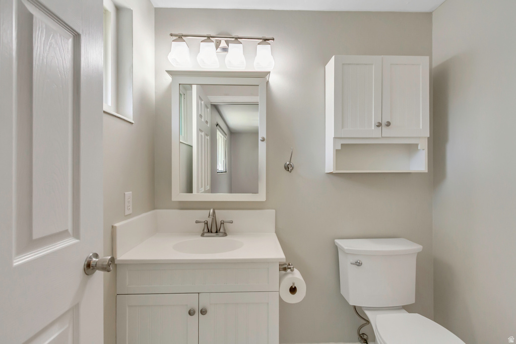 Bathroom featuring a white vanity with integrated sink, brushed nickel faucet, and a wall-mounted medicine cabinet