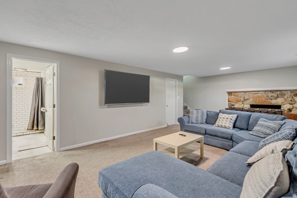 Carpeted recreation room featuring a stone-clad fireplace and recessed lighting