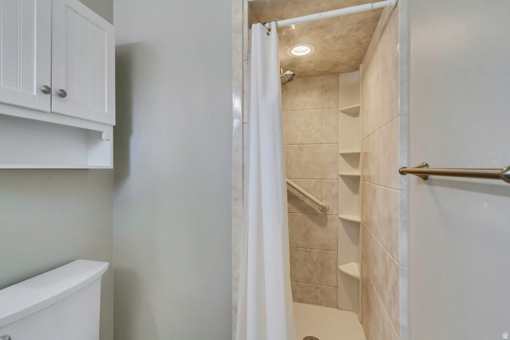 Tiled walk-in shower with a recessed light fixture and integrated corner shelving