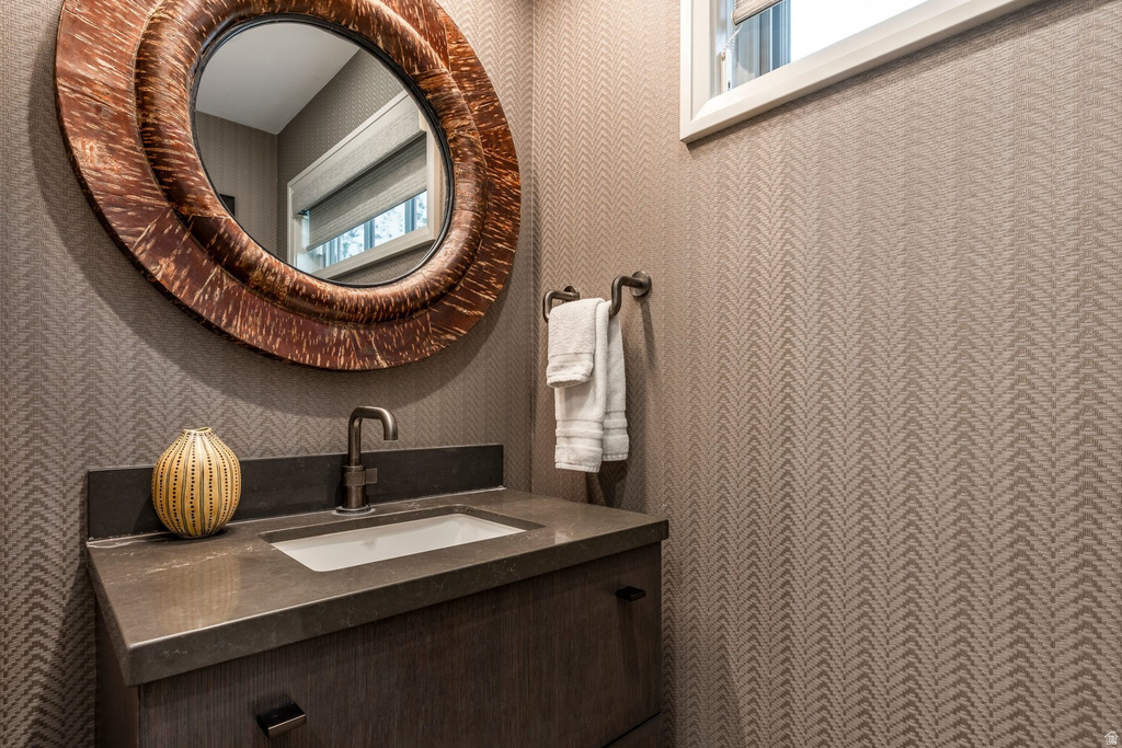 Vanity with integrated sink, bronze-finish faucet, and coordinating dark countertop