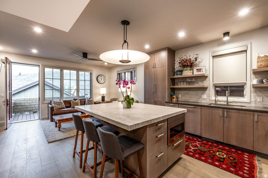 Kitchen island with stone countertop, integrated microwave, and seating for three