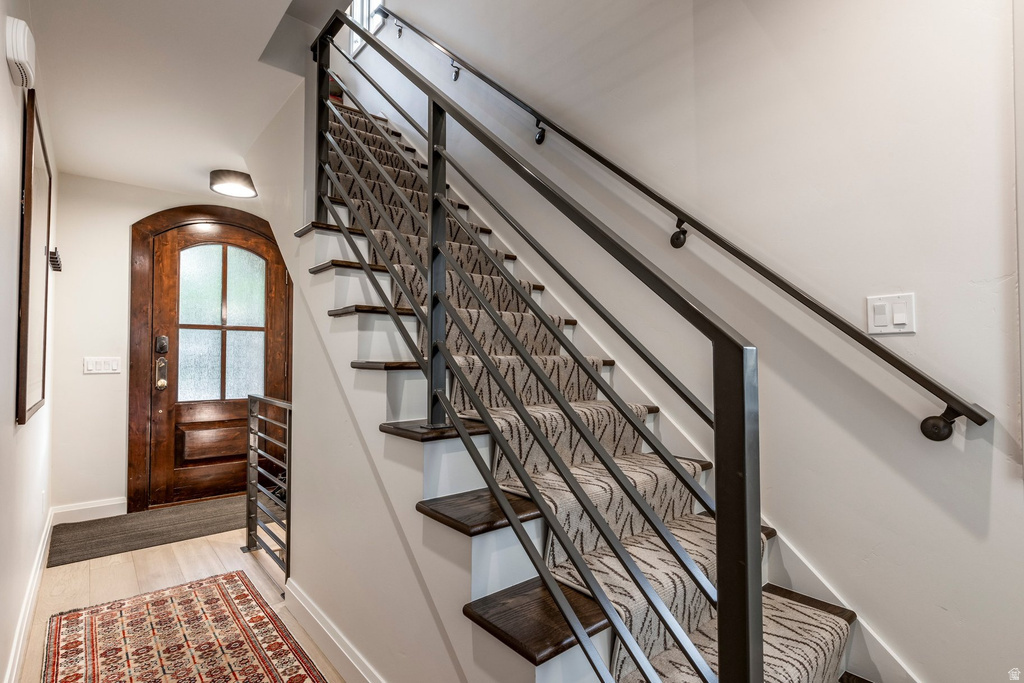 Staircase featuring dark metal railings and a patterned stair runner