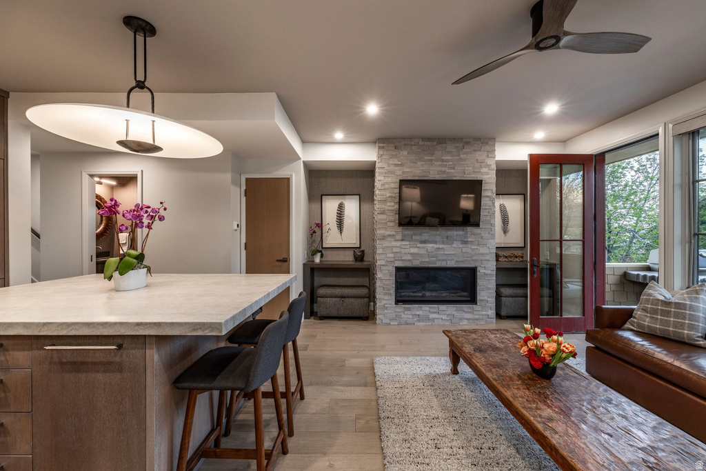 Open-concept living area with a stone-clad fireplace and integrated television