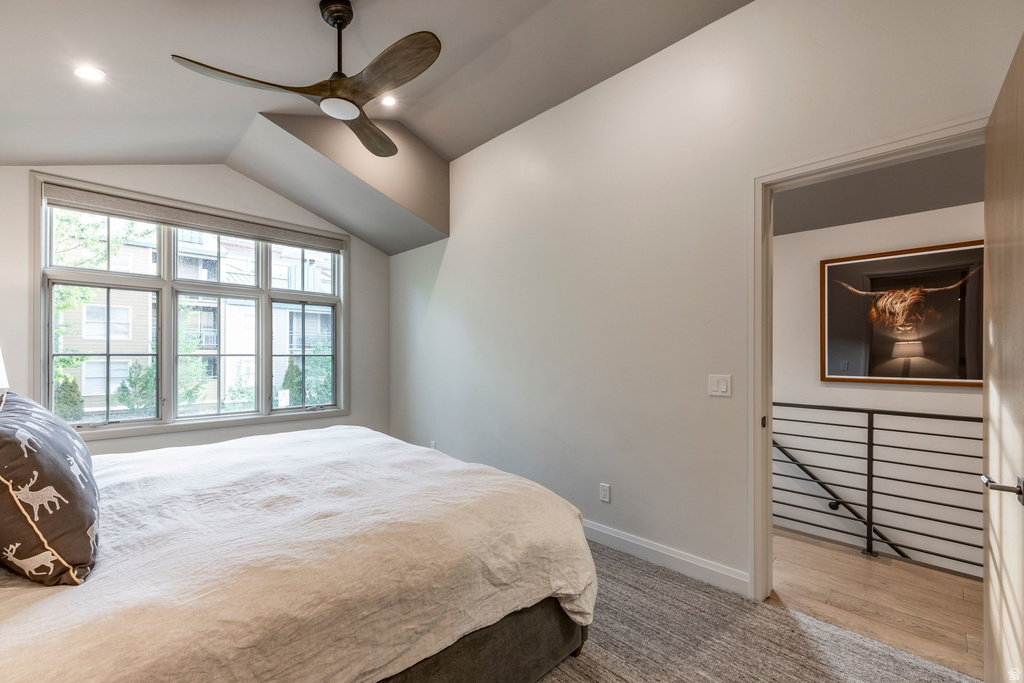 Bedroom featuring a multi-pane window, sloped ceiling, recessed lighting, and a contemporary ceiling fan