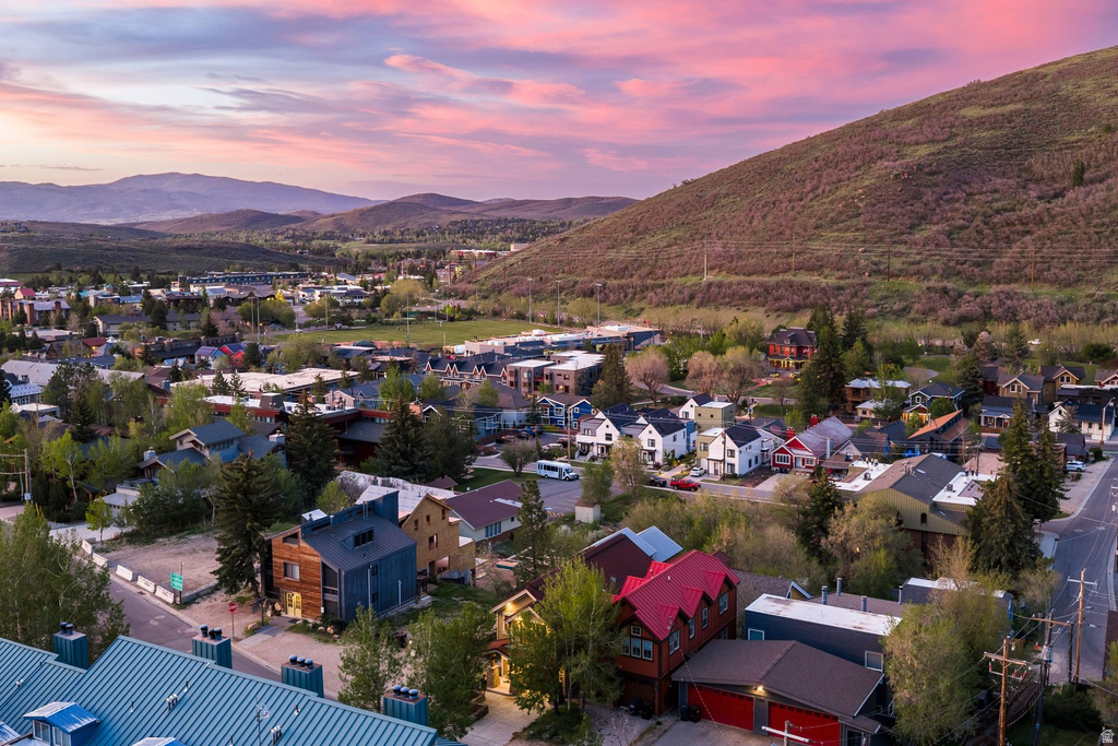 Aerial perspective showcasing a residential community nestled at the base of a verdant hill