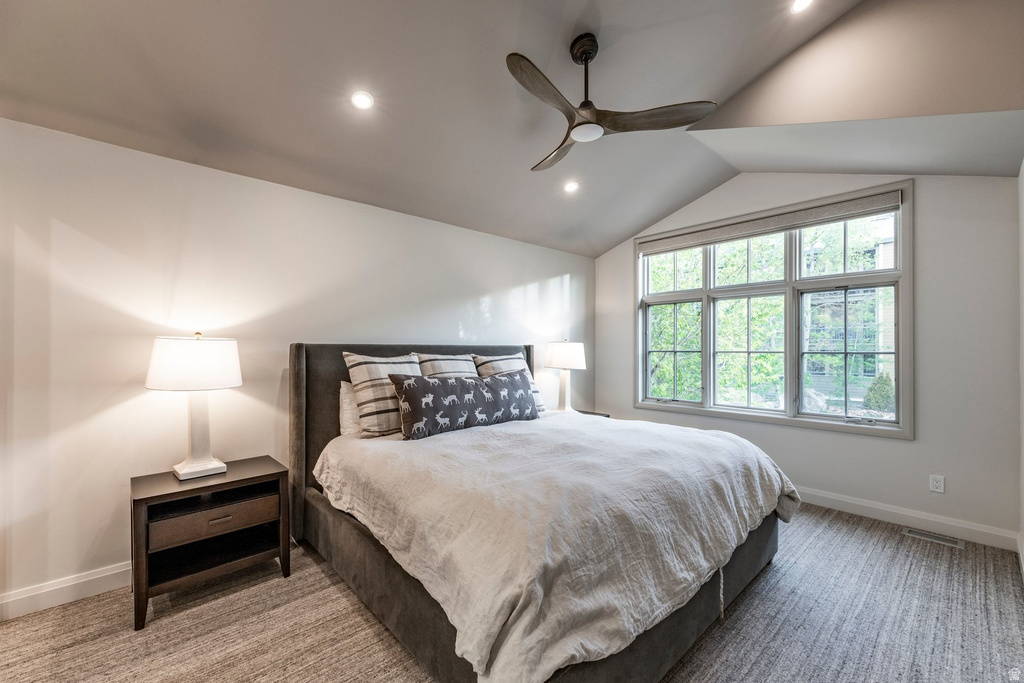 Vaulted ceiling bedroom featuring a large multi-pane window, recessed lighting, and a contemporary ceiling fan