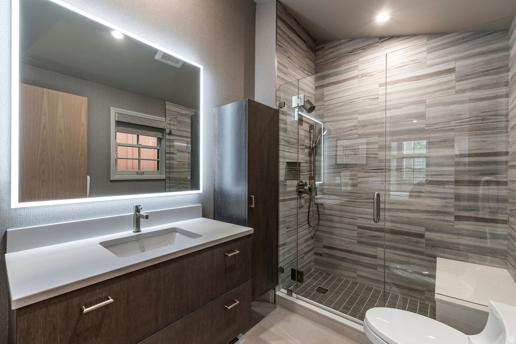 Modern bathroom featuring a single vanity with a solid surface countertop, an integrated rectangular sink, and a backlit mirror
