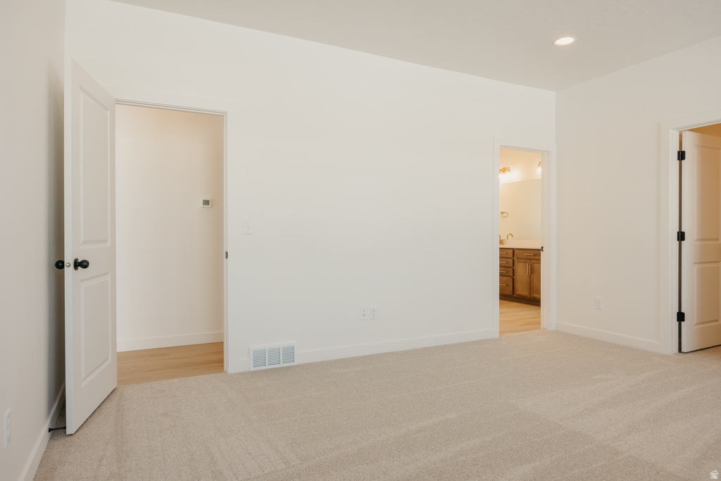 Spacious room with plush carpeting, recessed lighting, and crisp white walls