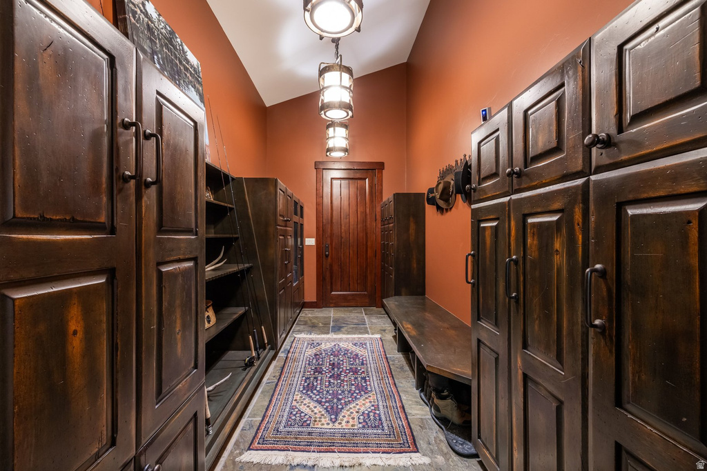 Hallway featuring extensive built-in cabinetry with dark wood-finish paneling and dark hardware