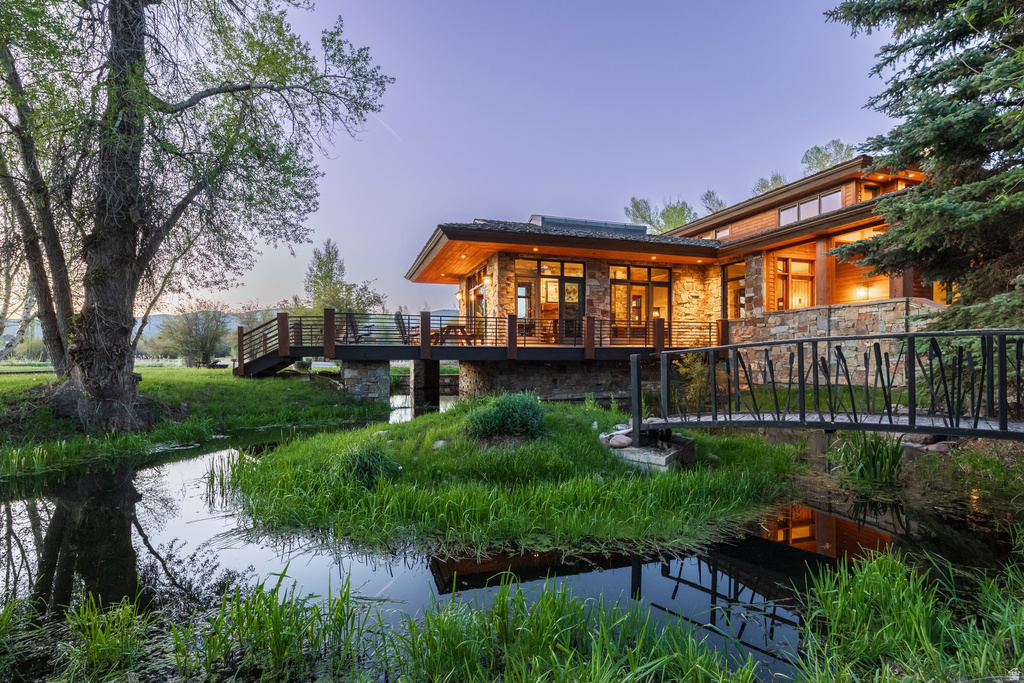 Architectural residence featuring a stone and wood facade