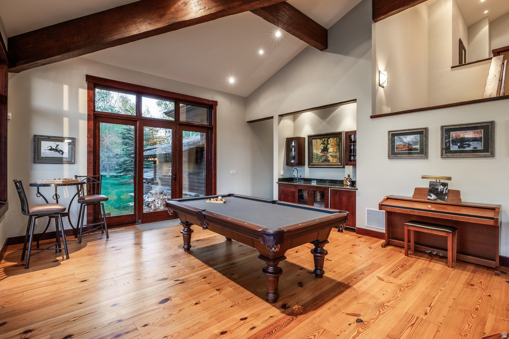 Spacious room featuring exposed wood ceiling beams and wood-finish flooring