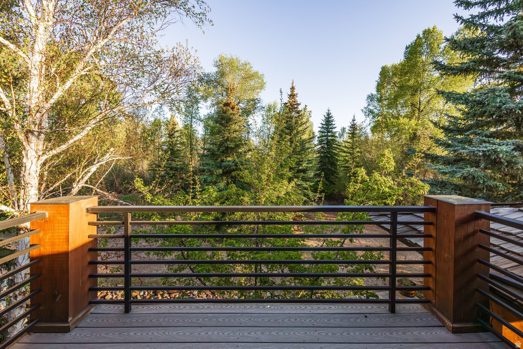 Outdoor deck featuring composite flooring, horizontal metal railings, and natural wood posts