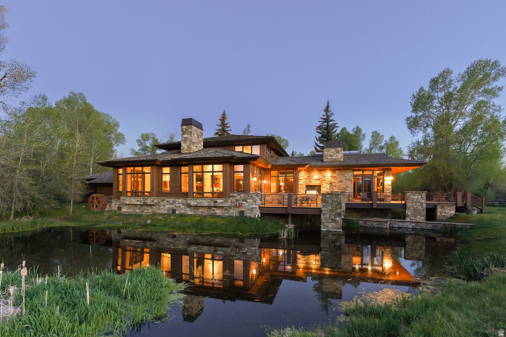 Stone and wood-clad exterior with extensive window placements overlooking a private pond