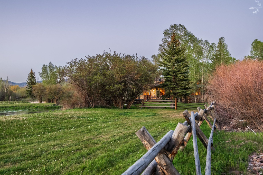 Expansive green lawn bordered by a traditional split-rail fence
