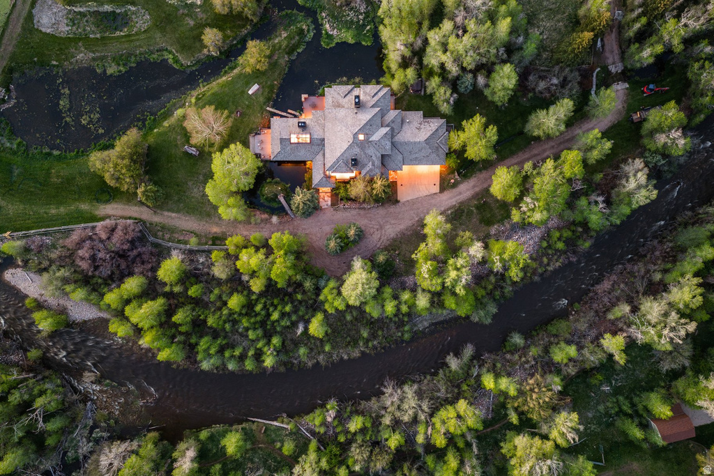 Expansive property featuring a multi-gabled residence, surrounded by mature trees and a winding river