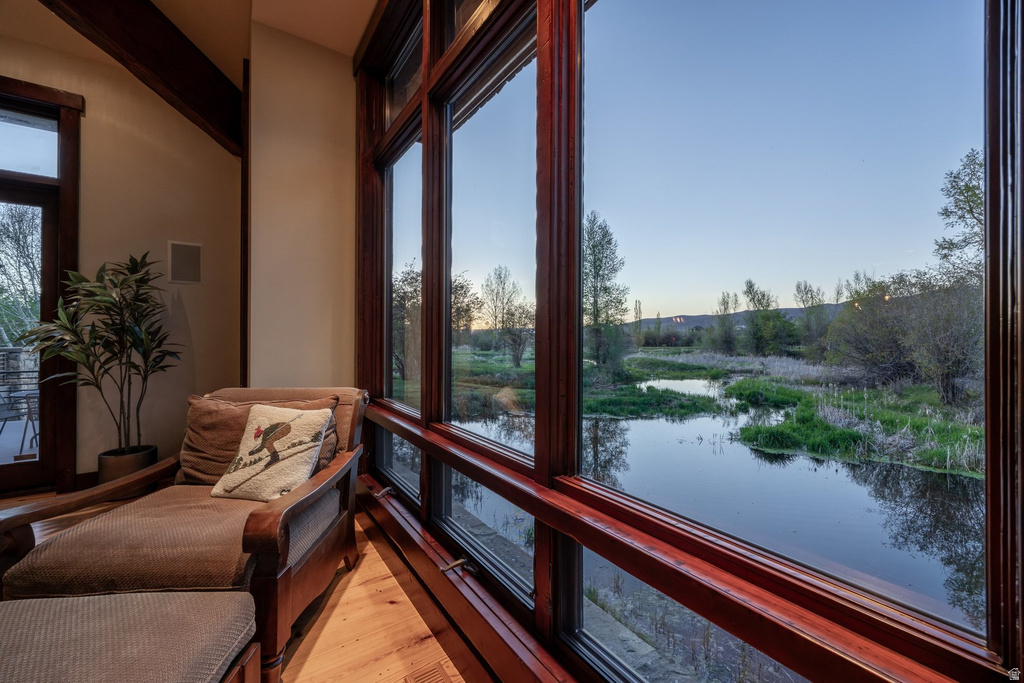 Expansive window wall with rich wood trim framing a tranquil river and natural landscape