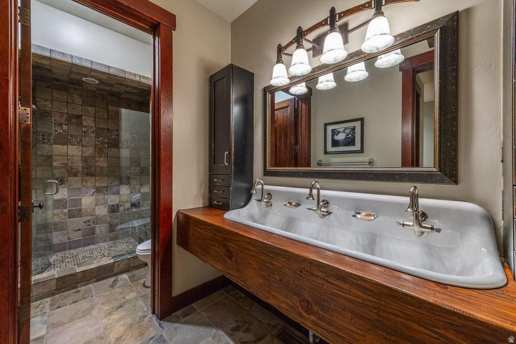Extended porcelain trough sink with multiple fixtures, set into a substantial wood-finish countertop