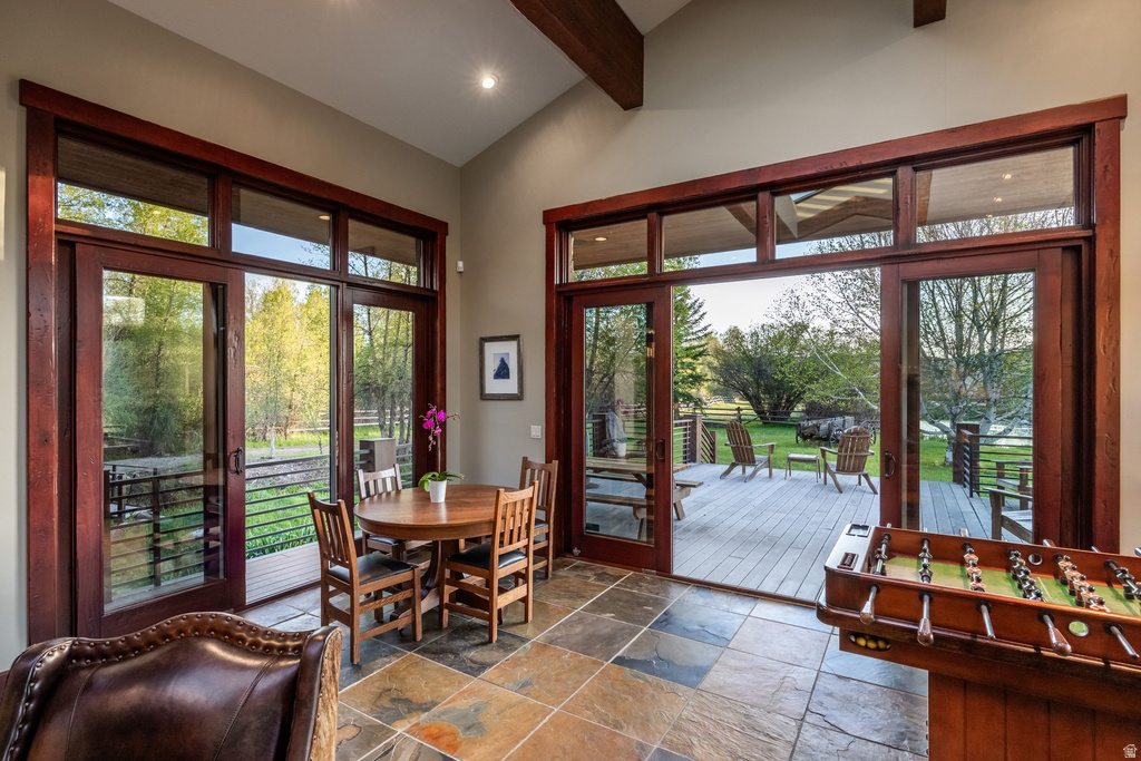 Spacious interior featuring high ceilings, exposed wood beams, and multi-tone slate tile flooring