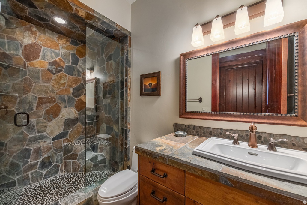 Walk-in shower featuring natural stone walls and a pebble floor