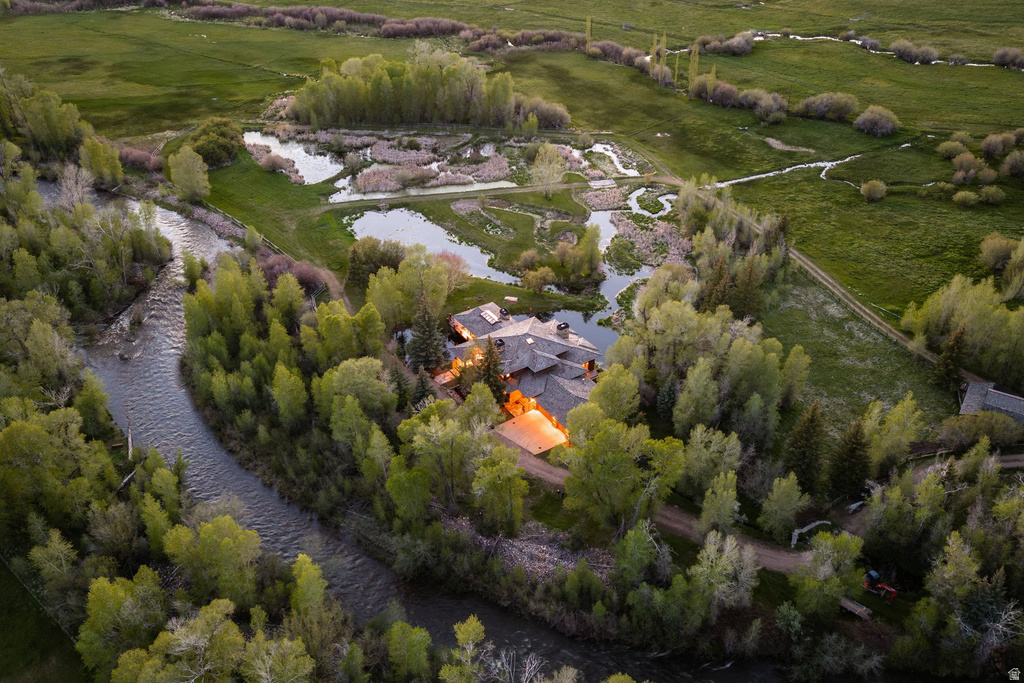 Extensive property featuring a winding river, multiple ponds, and verdant green fields
