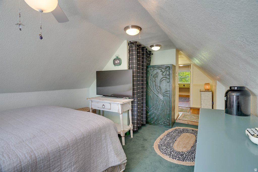 Sloped ceiling room featuring recessed and flush mount lighting, green carpeting, and an open doorway