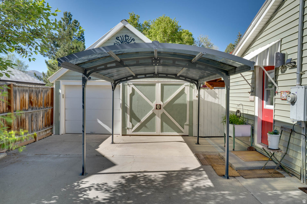 Concrete driveway leading to a detached garage and covered carport