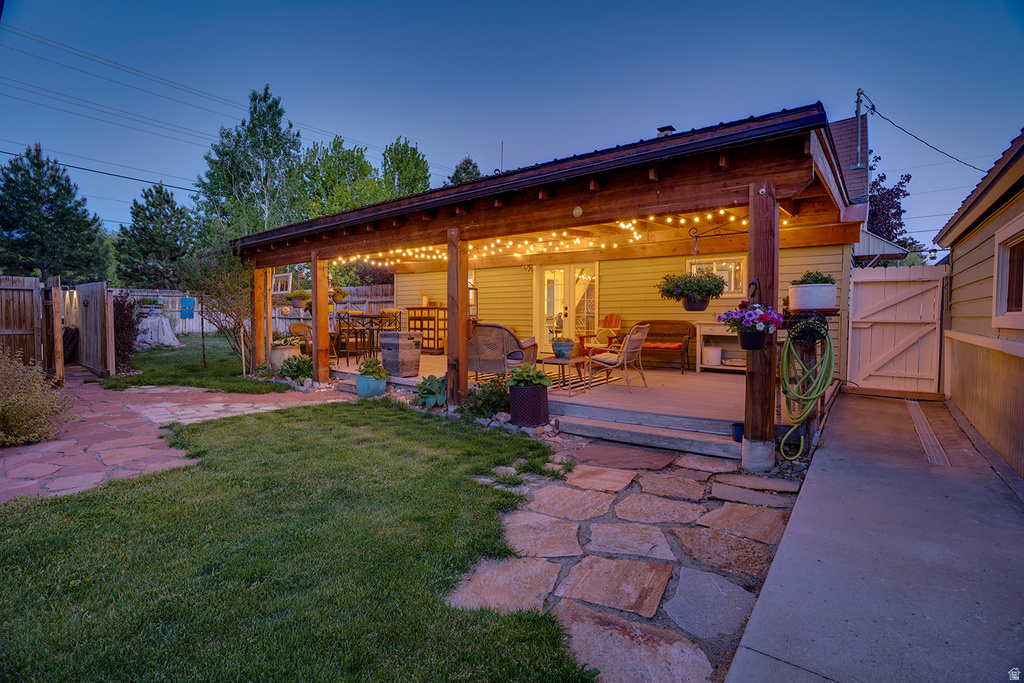 Covered back patio featuring wood beam construction and string lighting