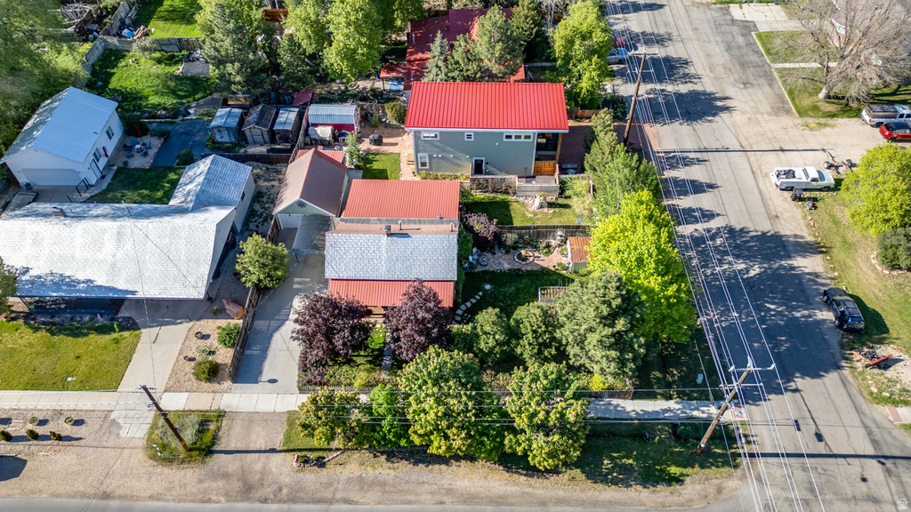 Aerial property view featuring a main residence with a red metal roof and an additional structure with a silver metal roof