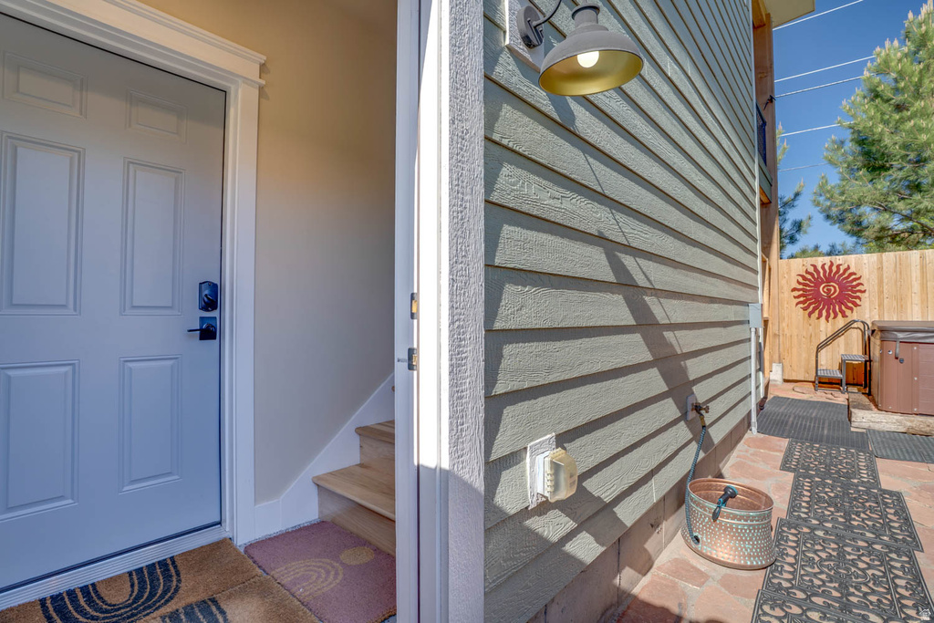 Private outdoor patio featuring brick pavers and a wood privacy fence