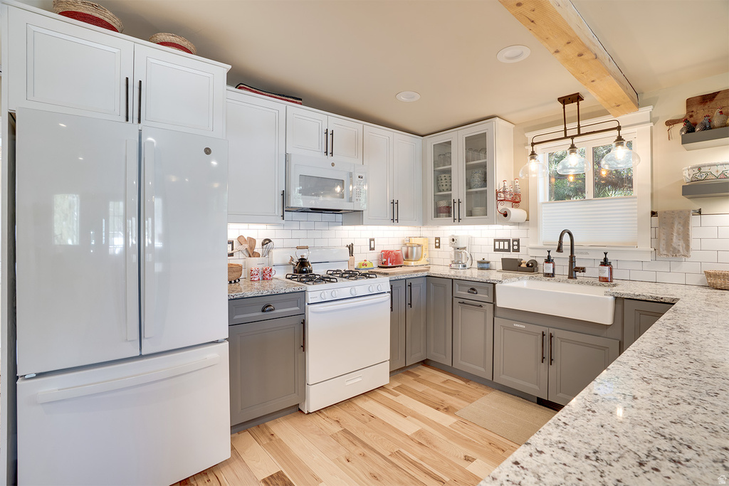 Well-appointed kitchen featuring a farmhouse-style sink, granite countertops, and two-tone cabinetry